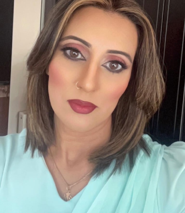 A woman with long brown hair smiles at the camera