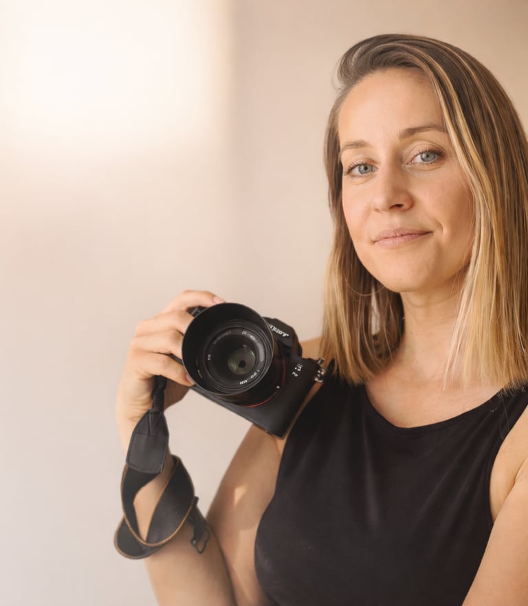 Professional family, wedding and event photographer in Brighton and Hove holding a camera.