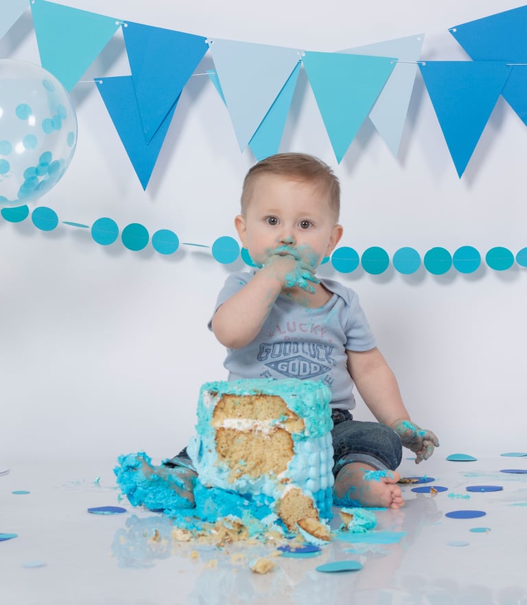a baby boy in a blue birthday cake