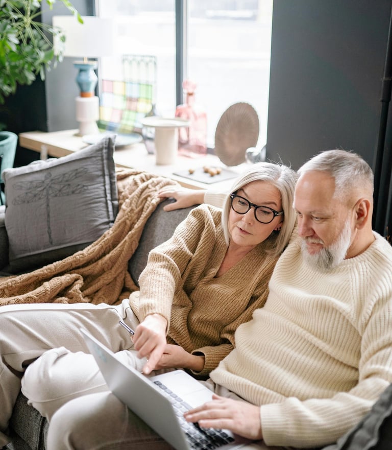 A woman and a man are looking at a laptop