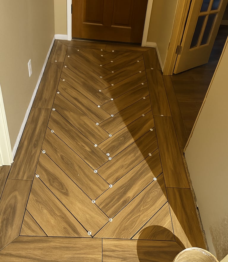 alt="Flooring installation in progress with herringbone tiles"