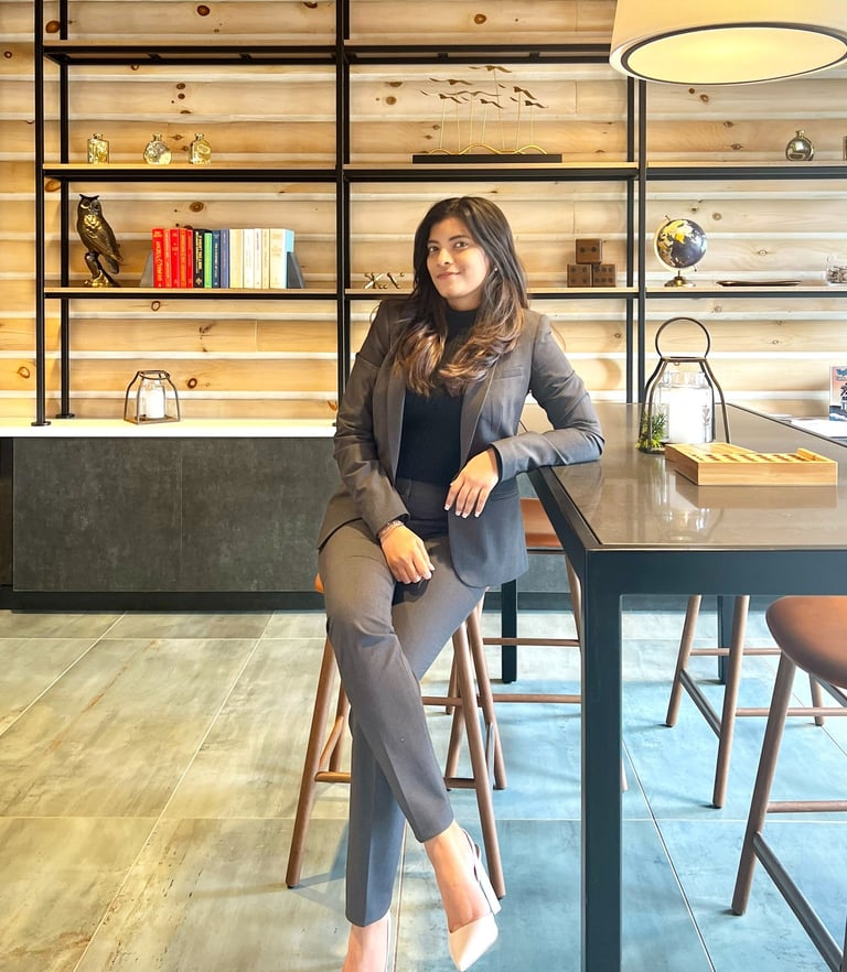 a woman sitting at a table with a lamp on it