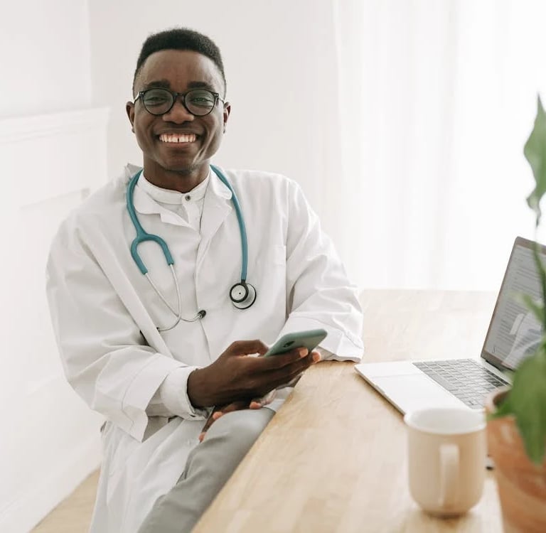 a male doctor in a white lab coat and a laptop