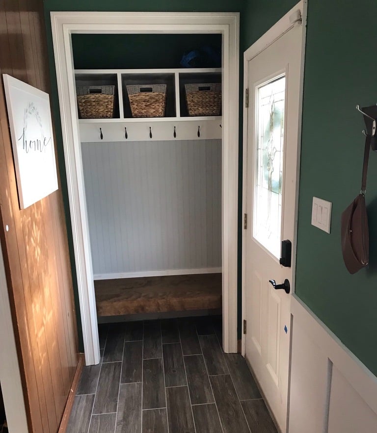 Mudroom with custom shelving floating stained bench beadboard and wood look tile