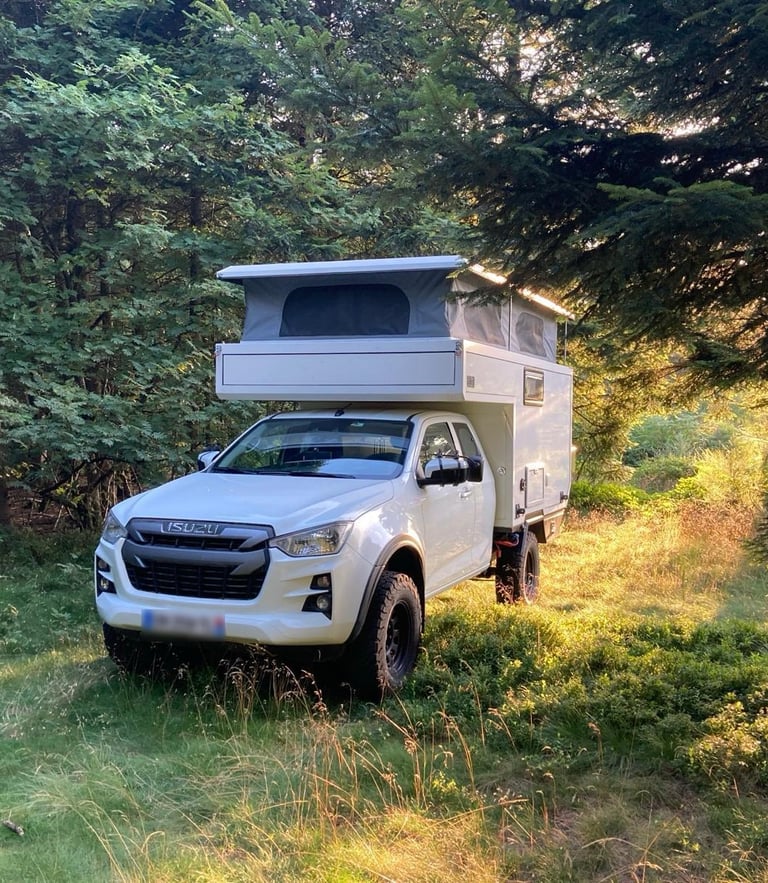una pick-up camper 4x4 con techo elevable en el bosque
