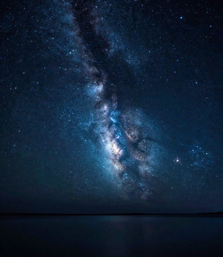 Wide-angle starry night sky reflecting on calm dark water, glowing nebulae in deep indigo and teal, soft luminous starlight, cinematic photography