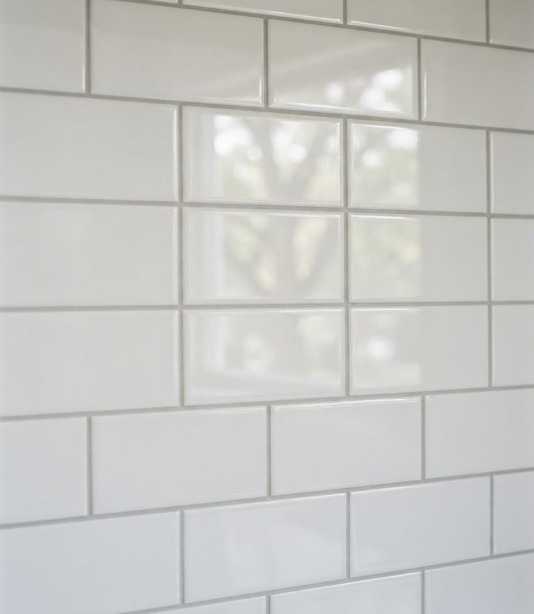 Close-up of a perfectly aligned, clean white subway tile backsplash in a bright Lansing kitchen, natural window light reflecting off the glossy glaze, neat grout lines, sharp focus, 35mm lens