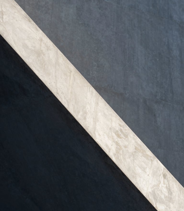 Minimalist concrete and marble architectural detail with sharp diagonal shadows and soft natural daylight, clean lines, elegant atmosphere