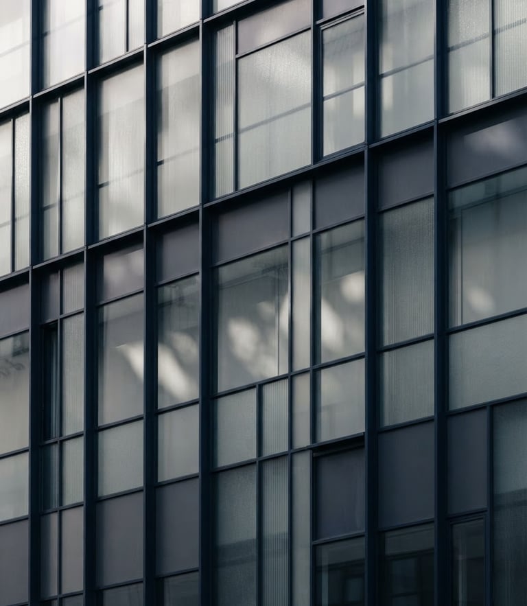 Abstract architectural details showing light filtering through glass panels, clean geometric composition, soft shadows, deep navy and muted gray tones