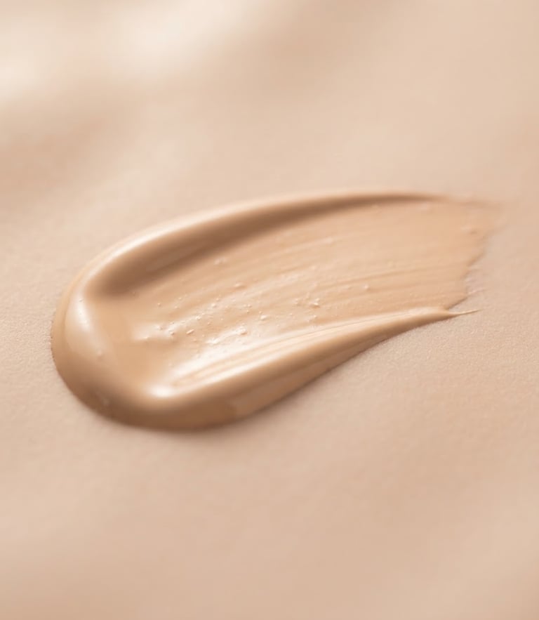 Macro shot of a pristine, silky liquid foundation swatch on a soft nude surface, elegant studio lighting, shallow depth of field