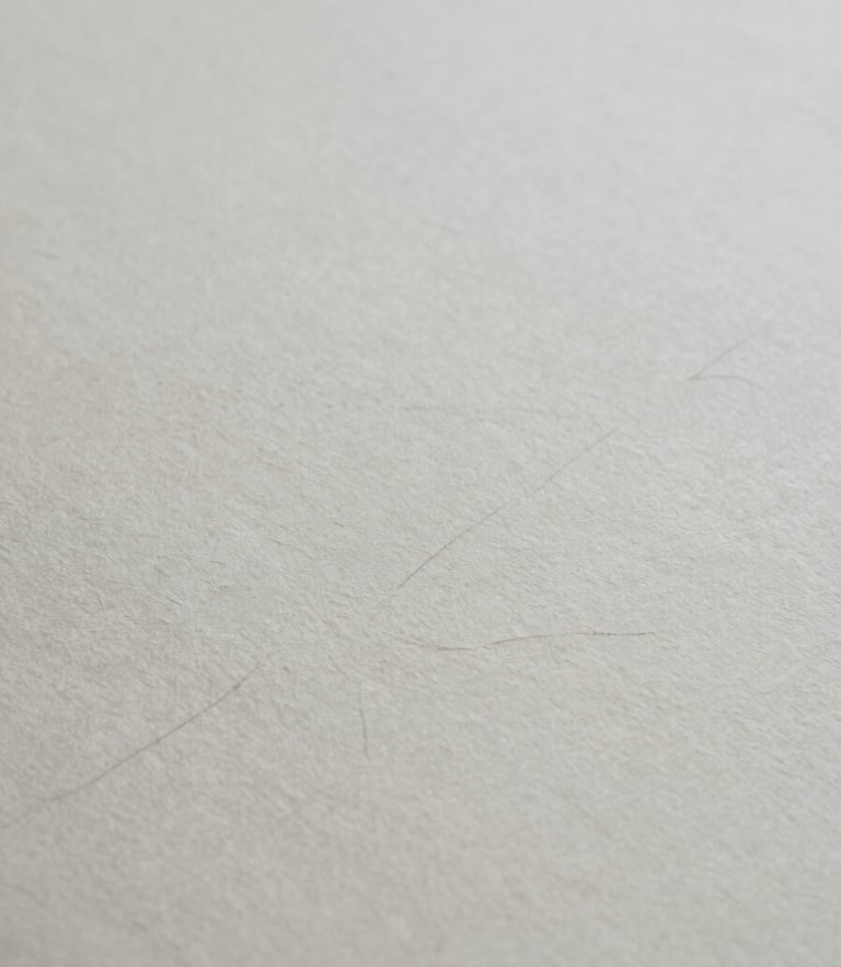 Extreme close-up of textured heavy handmade paper with faint fountain pen ink strokes, soft overcast natural light, desaturated slate tones, 35mm film grain
