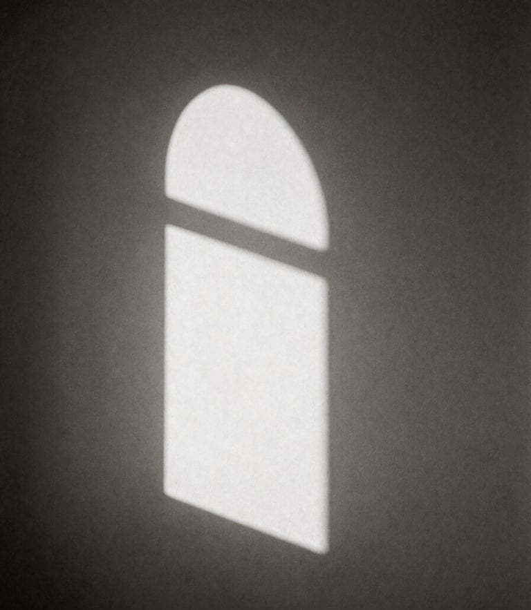 Minimalist black and white photography, soft natural window light casting a long sharp shadow of an arched window onto a bare plaster wall, high contrast, sepia undertones, elegant composition, 35mm film grain