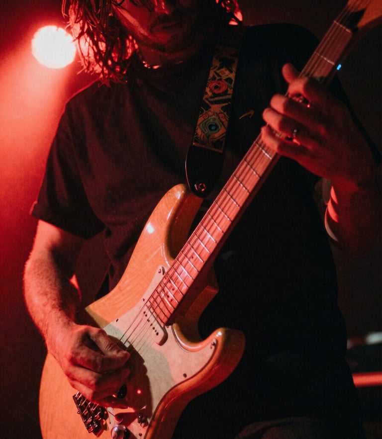 Gritty close-up of a musician's hands playing an electric guitar under harsh red stage lights, motion blur, 35mm film style.