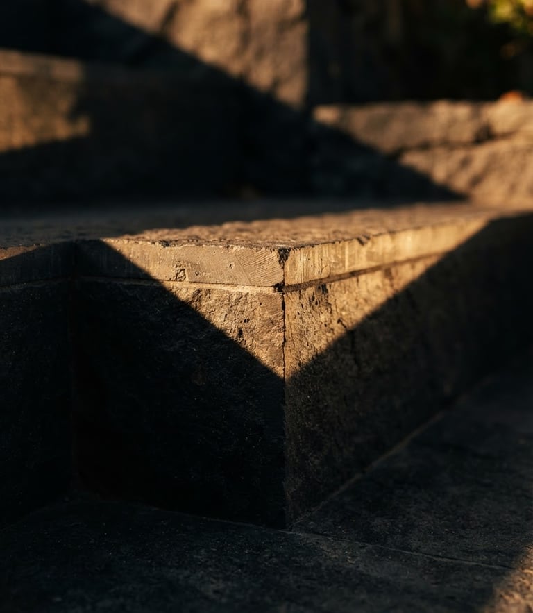 Macro photograph of modern architectural stone steps with sharp geometric shadows, warm golden sunlight brushing the edges, premium editorial, 35mm