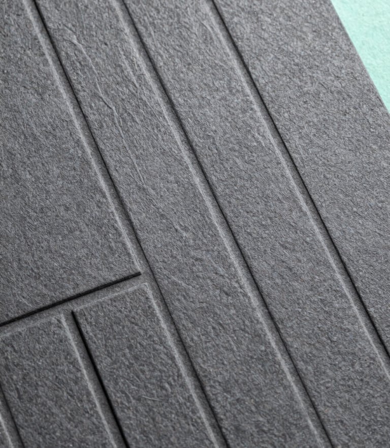 Extreme macro detail of high-end physical brand assets, textured charcoal paper debossed with clean geometric lines, cool daylight, sharp focus, Hasselblad medium format
