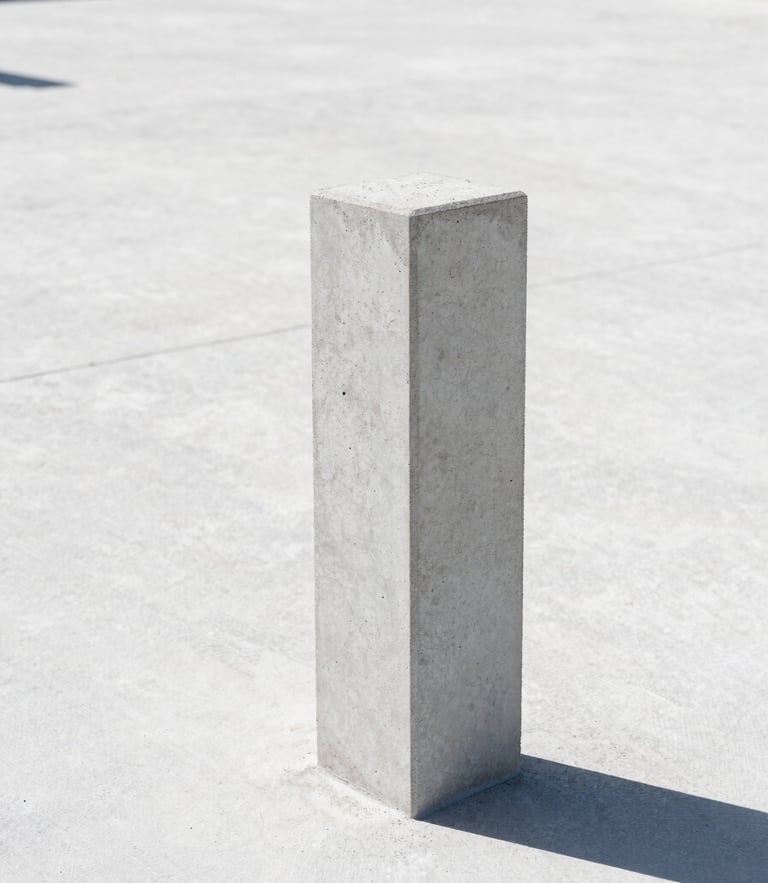 Eye-level architectural photography of a sharp concrete foundation marker on a clean, surveyed land parcel under bright natural daylight, high-contrast shadows, editorial 35mm.