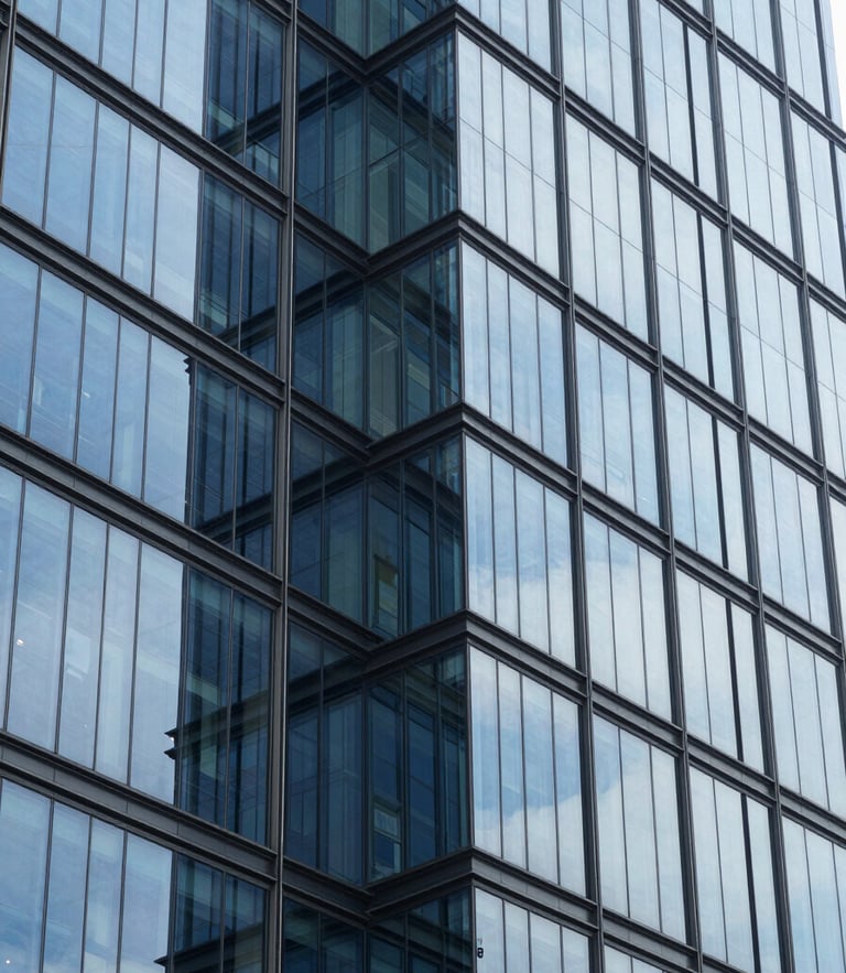 Crisp corporate photography, bright cool daylight, clean glass reflections, modern Bengaluru financial district building facade with structured geometric lines, 35mm