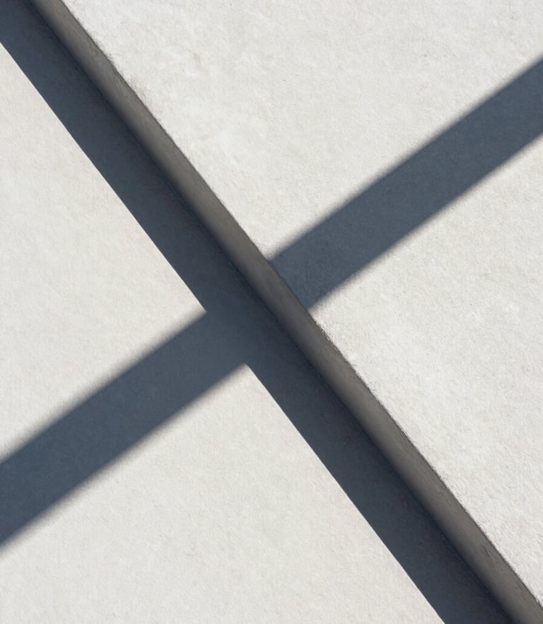 Extrema composición geométrica de una intersección de hormigón blanco bajo luz solar directa, sombras duras diagonales cruzando la superficie, estética de formato medio limpia y abstracta.
