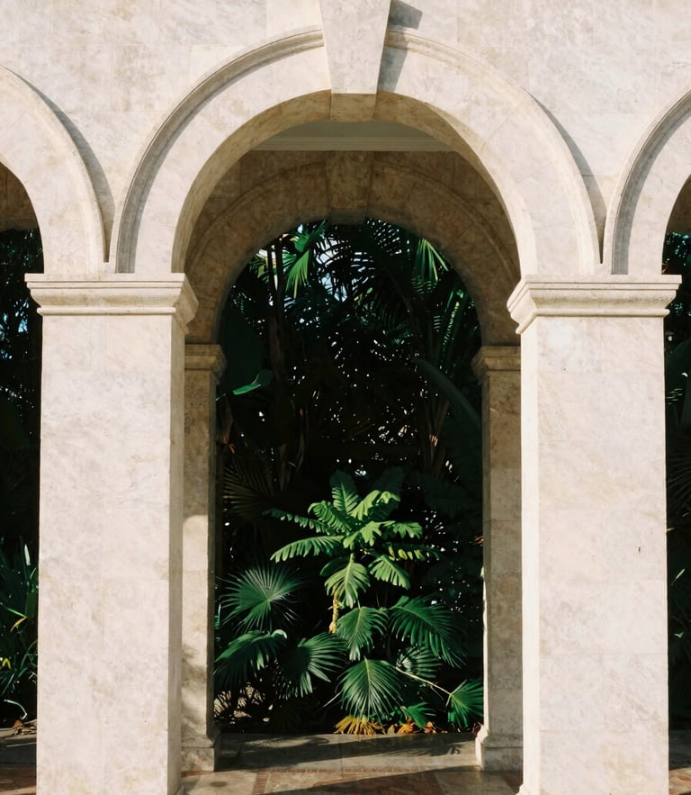 Warm editorial photography of Spanish-Mediterranean limestone arches in Coral Gables, soft natural morning light, deep forest green foliage shadow
