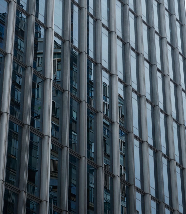 Abstract geometric pattern of glass and steel skyscraper facade, cool diffused daylight, deep blue and slate gray tones, architectural details, 35mm lens.