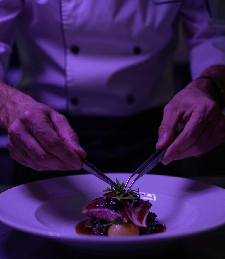 Dramatic close-up of a chef plating a dish with tweezers under moody violet kitchen lighting, high contrast, 35mm