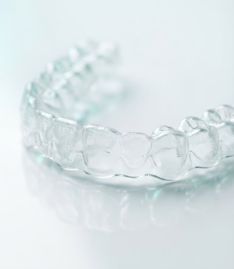 Macro studio photography of a crystal-clear medical polyurethane dental aligner, bright clinical lighting, clean white background with subtle medical teal reflections.
