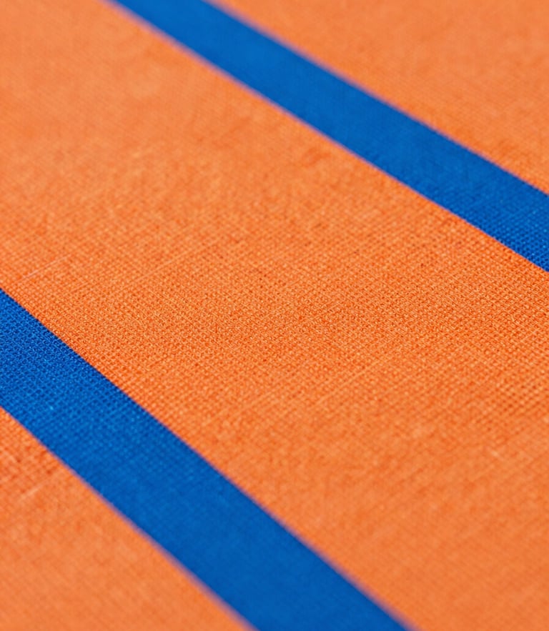 Crisp macro shot of textured technical athletic fabric, vibrant orange and blue fibers under high-key studio lighting, sharp focus