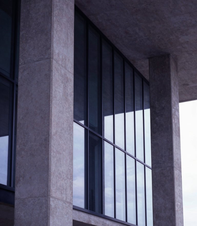 Low angle architectural shot of modern concrete and glass columns, soft natural light, minimalist corporate environment, 35mm