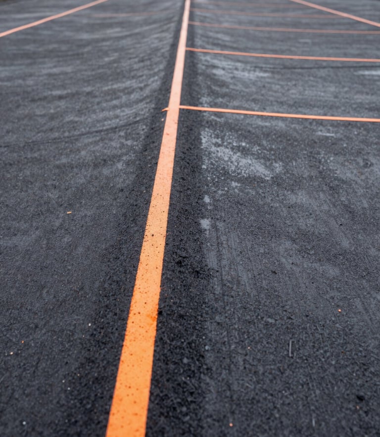 Close-up of a perfectly sealed roof seam on a commercial building, charcoal bitumen texture, safety orange marking lines, sharp focus