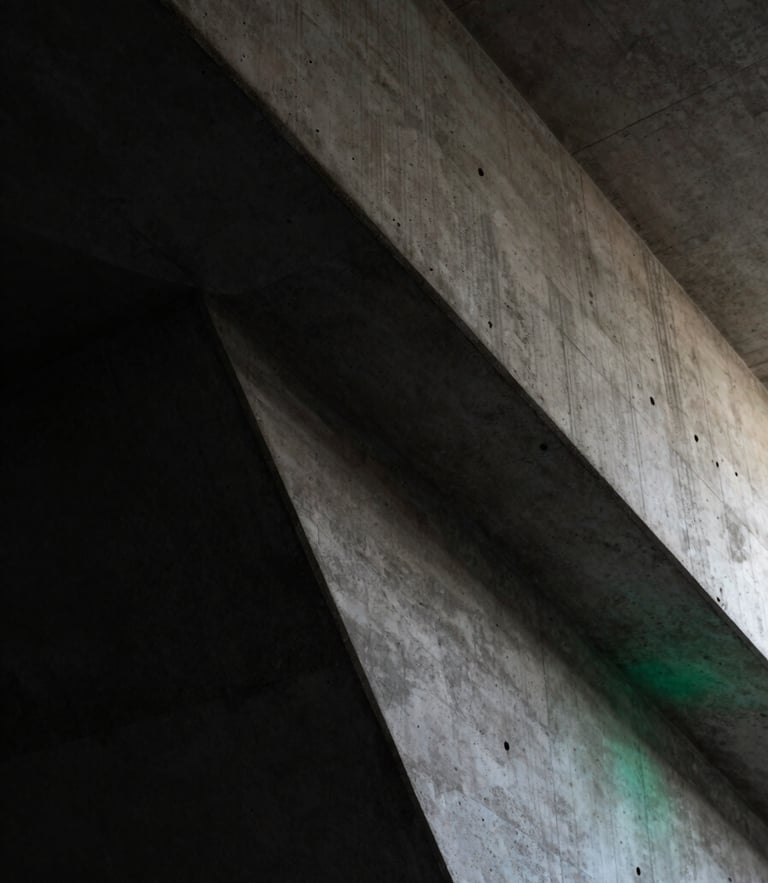 Extreme close-up of high-contrast architectural concrete angles in low-key lighting, deep charcoal shadows, subtle emerald ambient light leak.