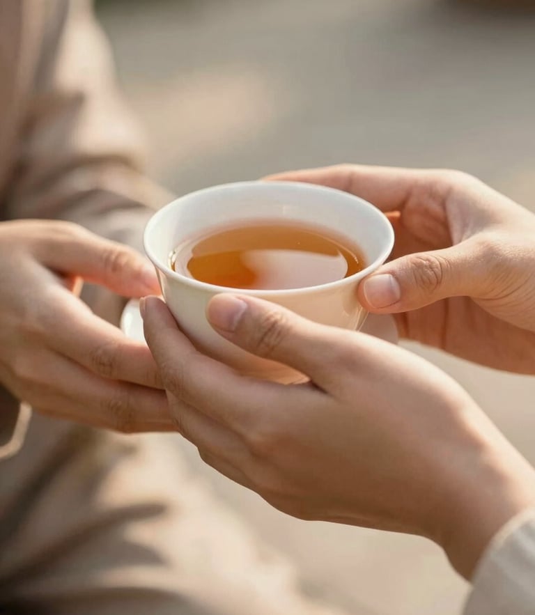 A close-up of hands offering a warm cup of tea to another person, soft golden-hour daylight, shallow depth of field, authentic human connection, warm editorial photography style.