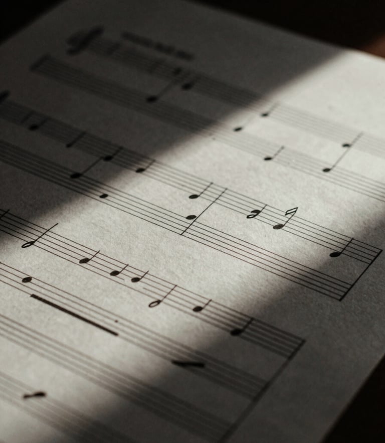 Chiaroscuro macro shot of handwritten musical manuscript paper with ink notations, soft natural side lighting, deep shadows, 35mm film grain
