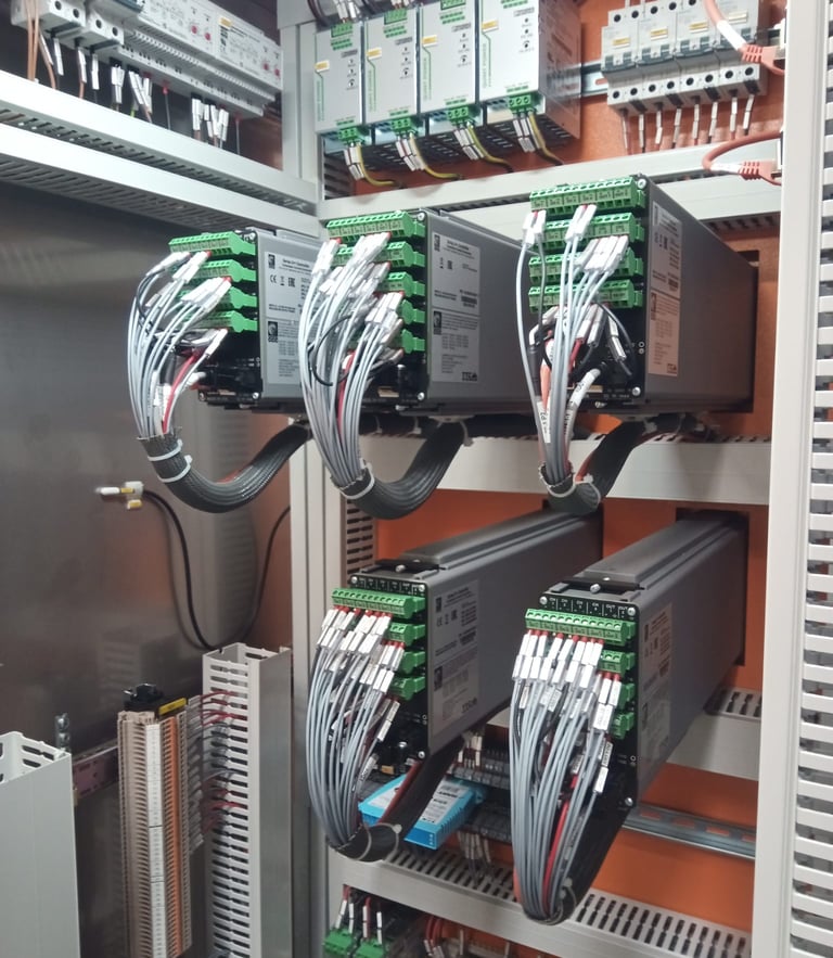 Industrial electrical control panel featuring organized PLC modules and wired servo drives for automation.