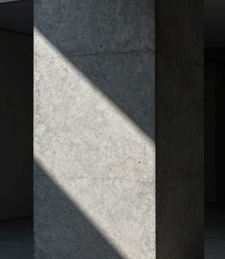 Portrait framing of a monolithic concrete column with sharp architectural shadows, cool diffused studio light, minimalist composition.