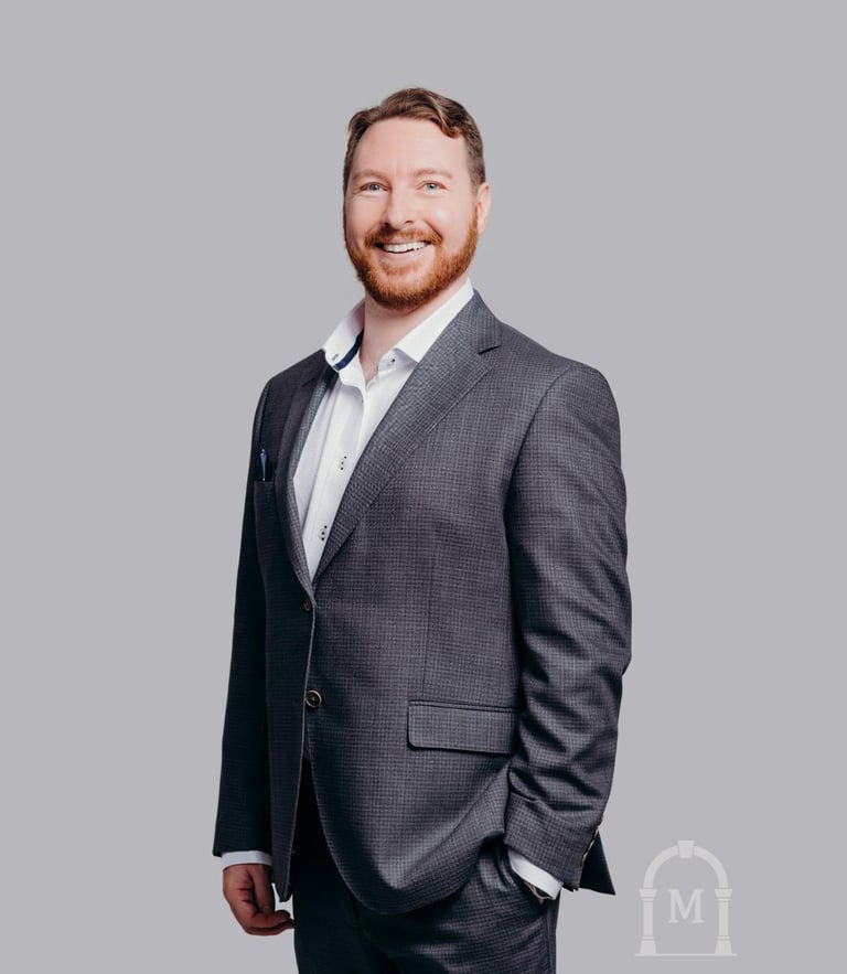Photo of Dustin Morris the Owner of Morris Household. He is wearing a dark grey suit and white shirt