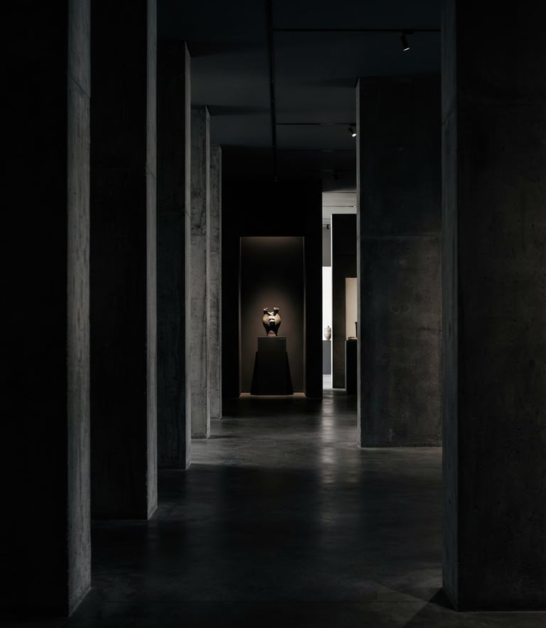 Dramatic low-key architectural interior, sharp concrete columns framing a pristine minimalist space, high-contrast shadows, 35mm lens photography.