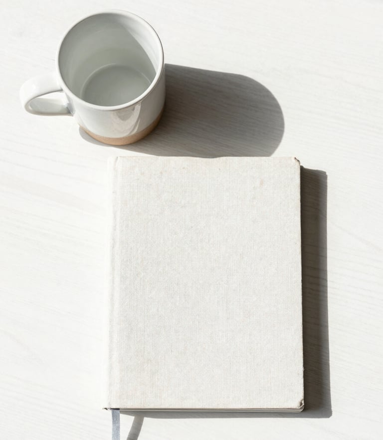 Overhead flat-lay of a heavy ceramic mug and a linen journal arranged with geometric precision on a white oak table, bright natural daylight, soft shadows.