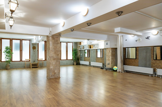 Sala de practică a centrului de yoga Alchimia Vieții din București, spațiu luminos cu oglinzi și plante