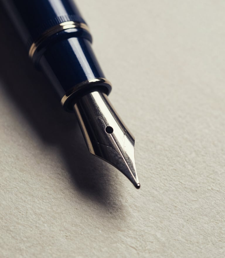 Macro close-up of a classic fountain pen nib resting on heavy, textured ivory paper, dramatic side-lighting, deep navy shadows, high contrast