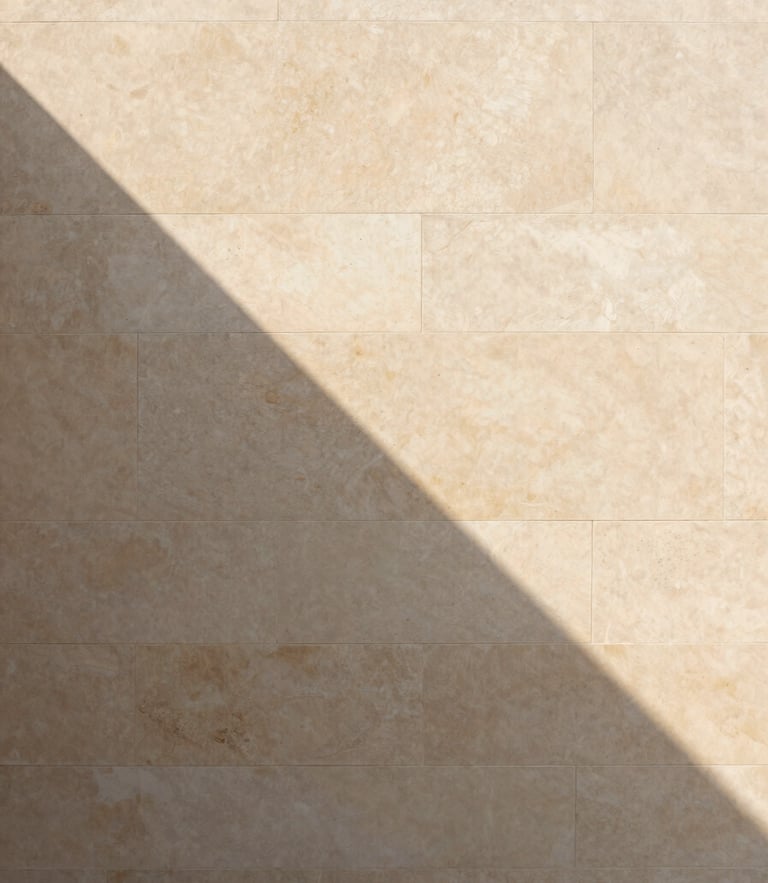Minimalist architectural detail of a warm stone wall, sharp geometric shadow cast by soft daylight, clean lines, elegant and serene, 35mm photography
