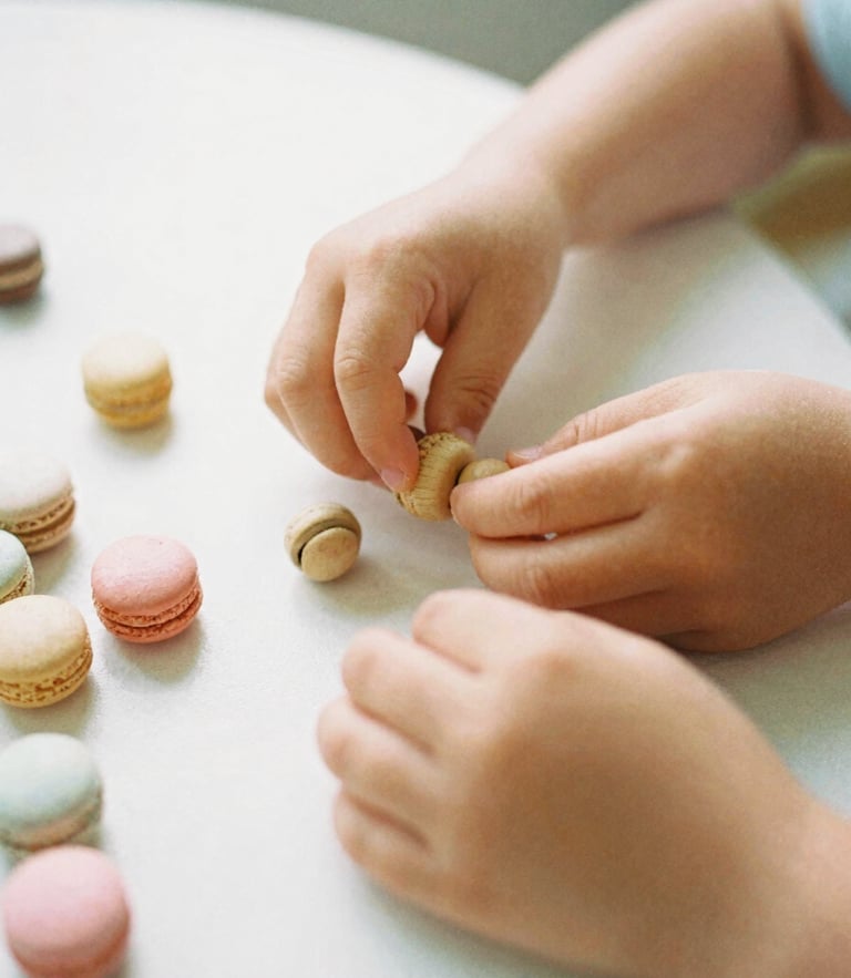 Eye-level candid photograph of a child's hands sorting smooth wooden beads on a sunlit table, soft morning daylight, gentle macaron pastel tones, shallow depth of field, 35mm film style