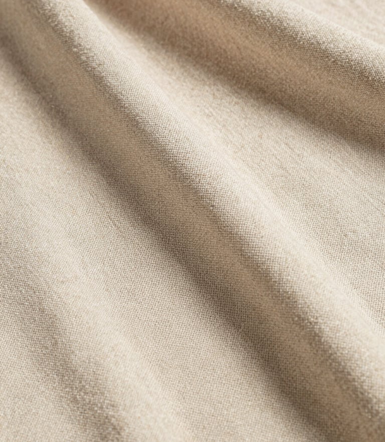 Extreme portrait-oriented close-up of heavy linen fabric swatch in champagne beige, soft natural daylight casting gentle shadows, showing detailed weave and texture