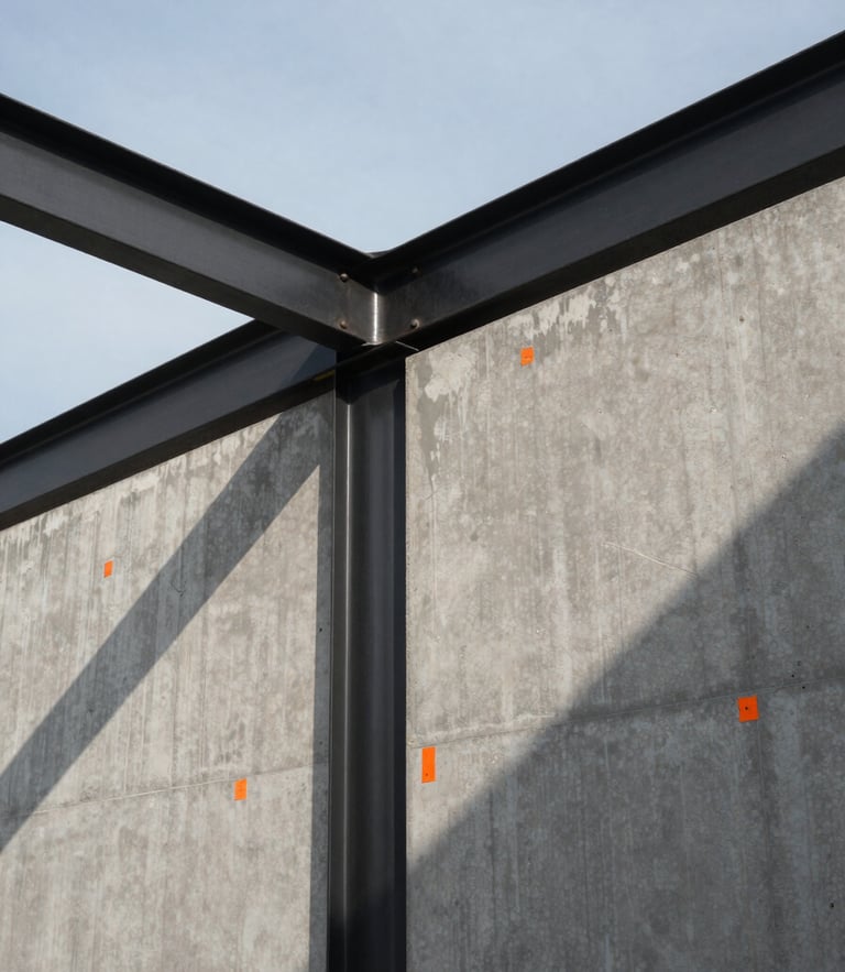 Wide panoramic 21:9 view of a blackened steel beam intersecting a raw concrete wall, sharp safety-orange construction markings visible, heavy geometric shadows cast by low-angle morning sun, generous negative space.