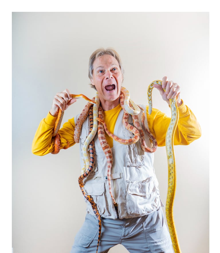 Rick holding an assortment of snakes in a yellow shirt and vest