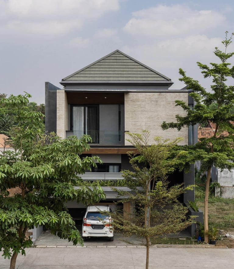 Rumah modern 2 lantai di Royal Estate Podo dengan fasad elegan, balkon kaca, dan area carport, mengh