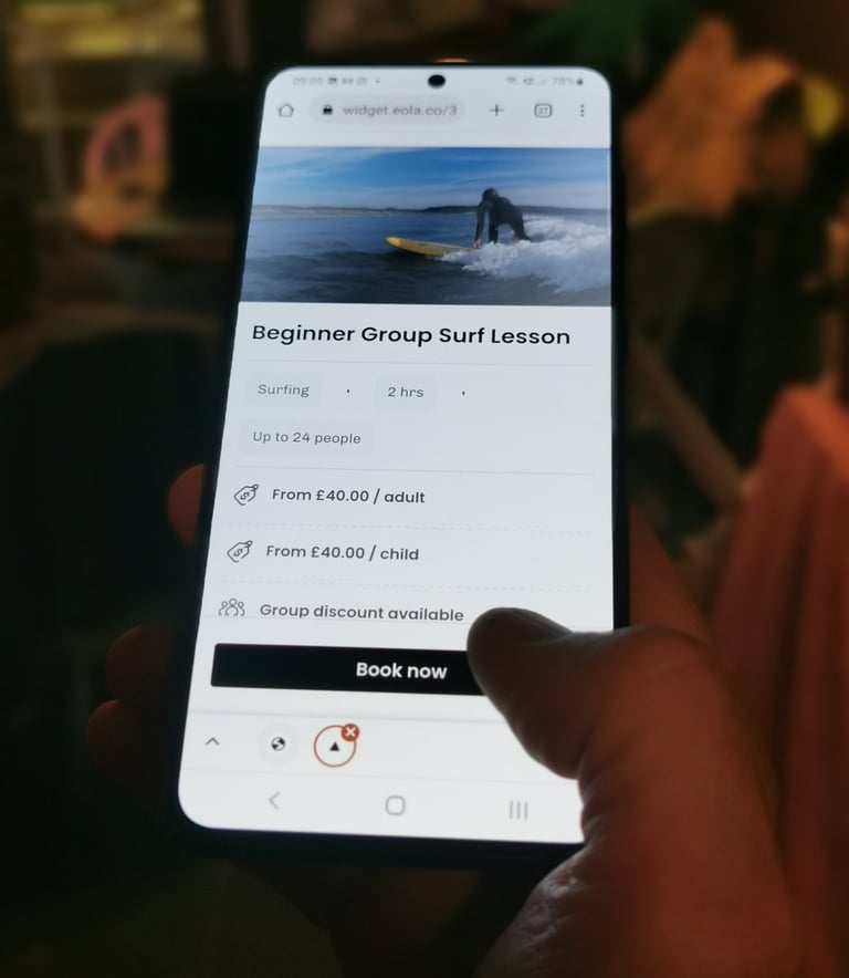 A mobile phone displaying a booking page someone clicking book now