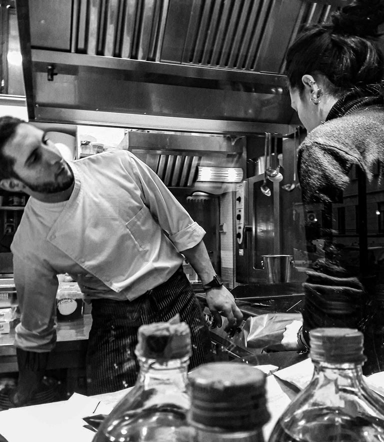a man and woman in a kitchen with jars of jars