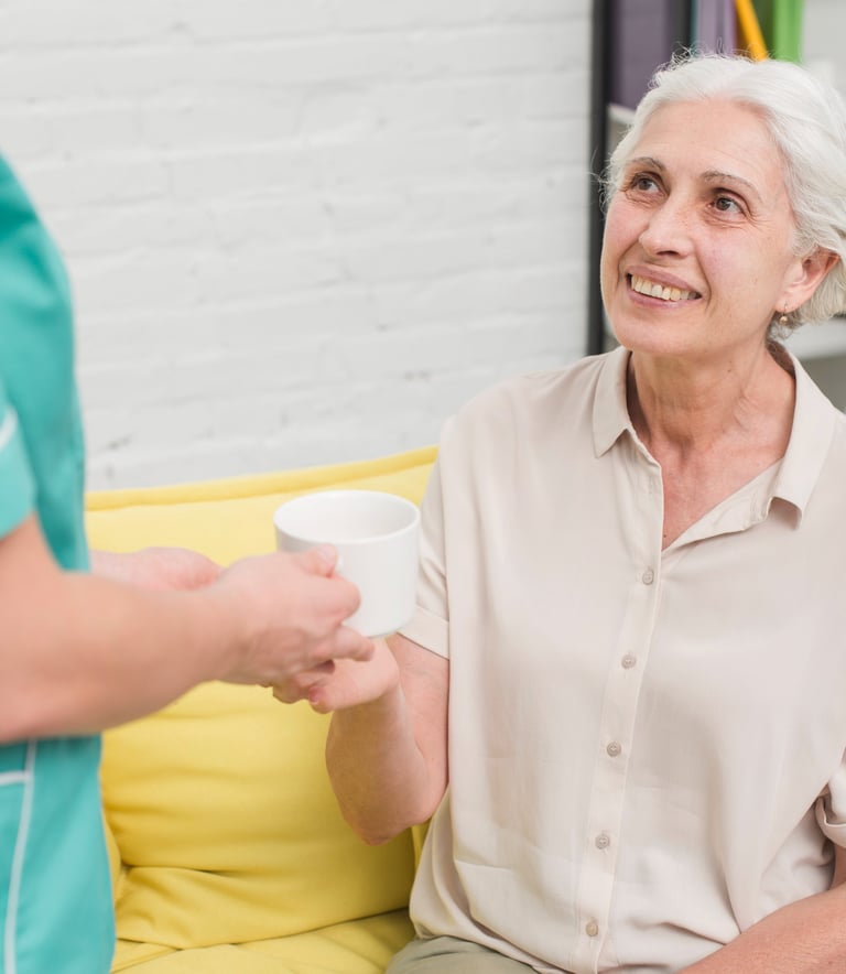 a caregiver reminding a senior woman to take her medicines