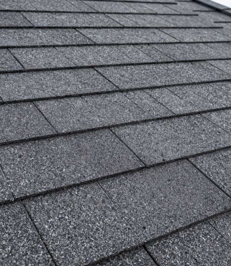 Close-up photography focusing on the texture and layered installation of high-quality architectural roofing shingles in Dark Slate Gray. Sharp detail, professional lighting, North American / US residential style.