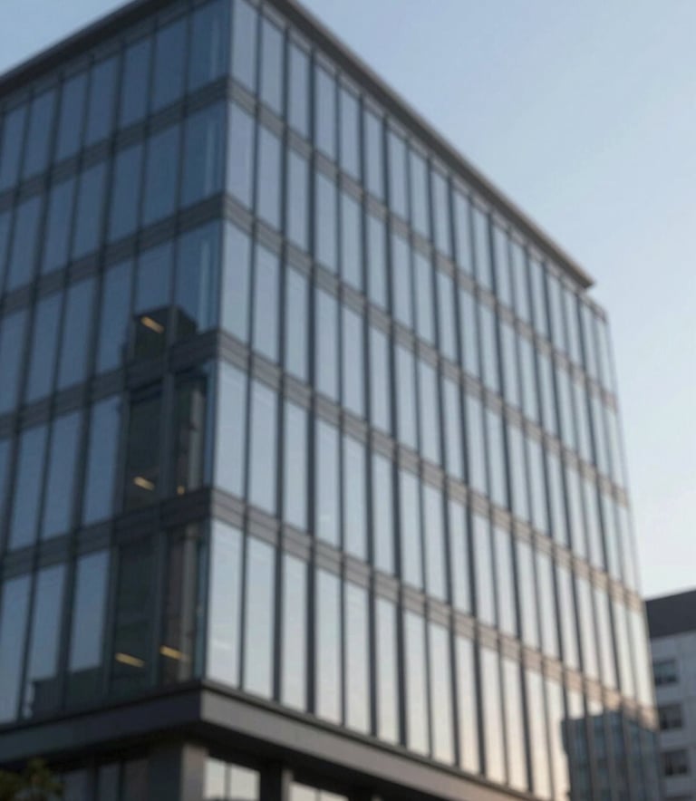 A sleek, modern commercial office building with glass windows reflecting a clear blue sky, emphasizing refined professionalism and architectural reliability, featuring tones of #1E272C and #A5B6C0.